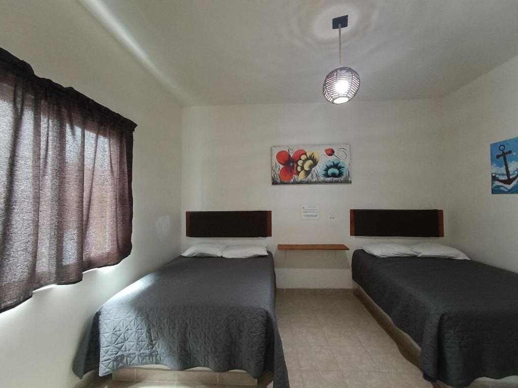 una camera con due letti e una finestra di Condominio Casas Mandala a Costa Esmeralda