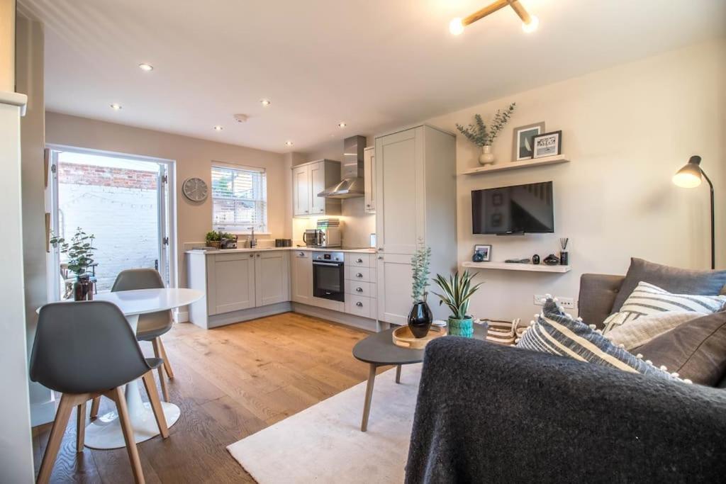 uma sala de estar com um sofá e uma mesa em Luxurious newly built cottage in central Wivenhoe em Wivenhoe