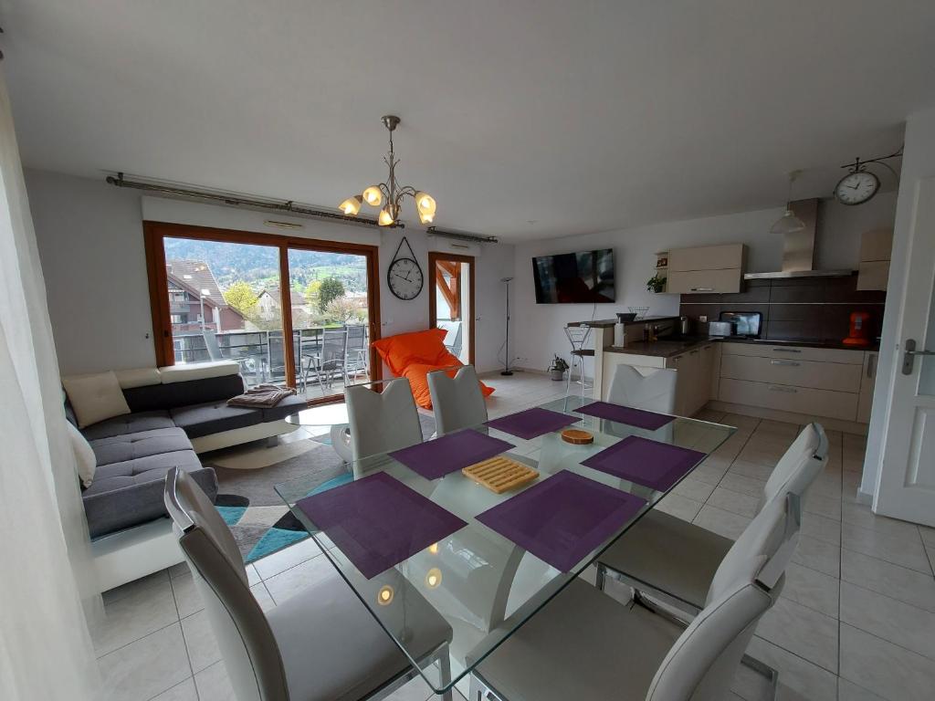 - une cuisine et une salle à manger avec une table et des chaises dans l'établissement Au cœur de St Jorioz, spacieux appartement avec terrasse et vue montagne., à Saint-Jorioz