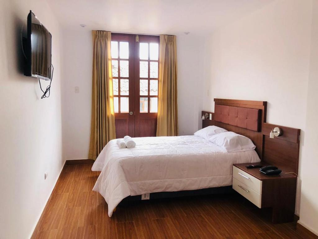 a bedroom with a large bed and a television at Hotel Silva Inn in Cajamarca