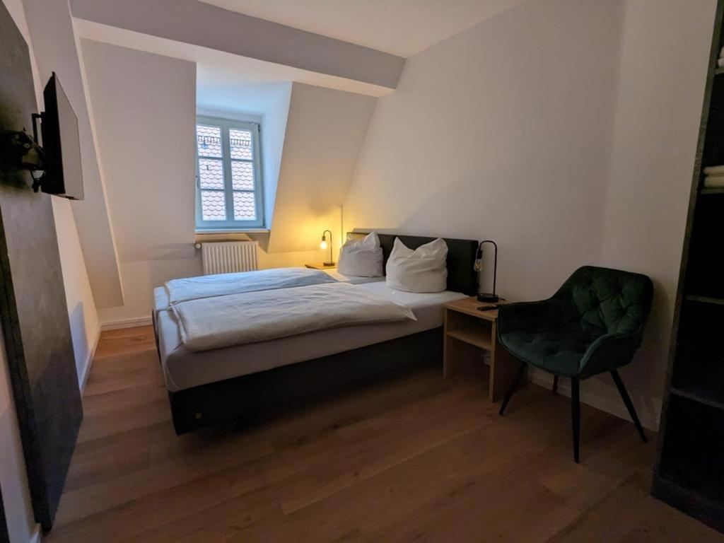 バンベルクにあるHotel CASA ITALIAの小さなベッドルーム(ベッド1台、椅子付)