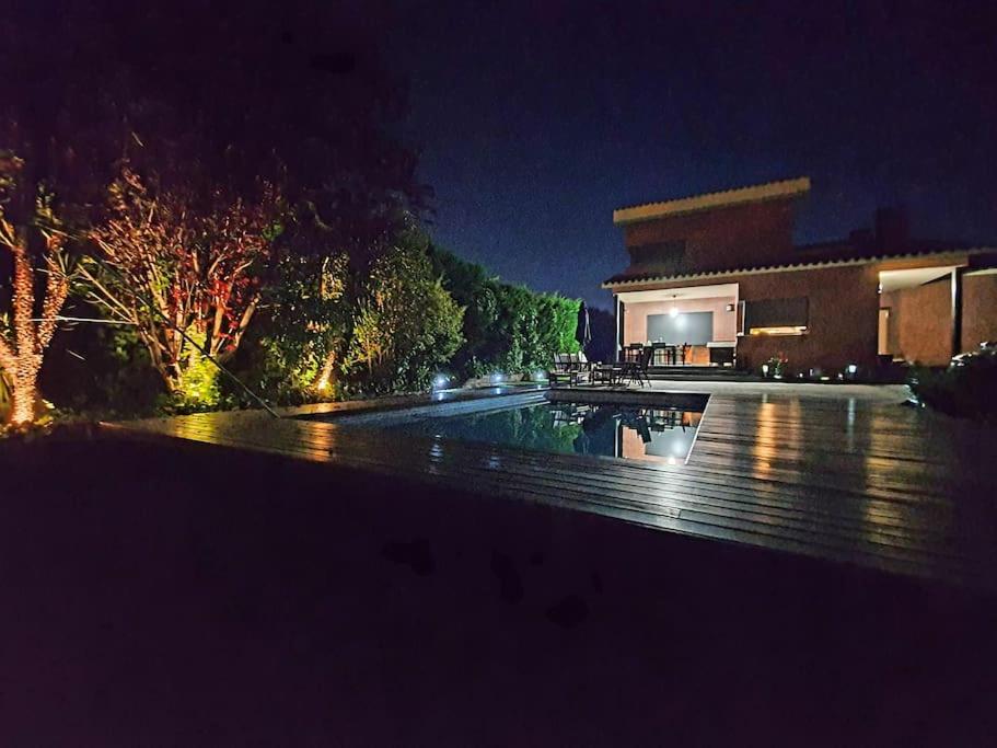 una piscina frente a un edificio por la noche en Montserrat Villa Deluxe Barcelona en Vacarisas