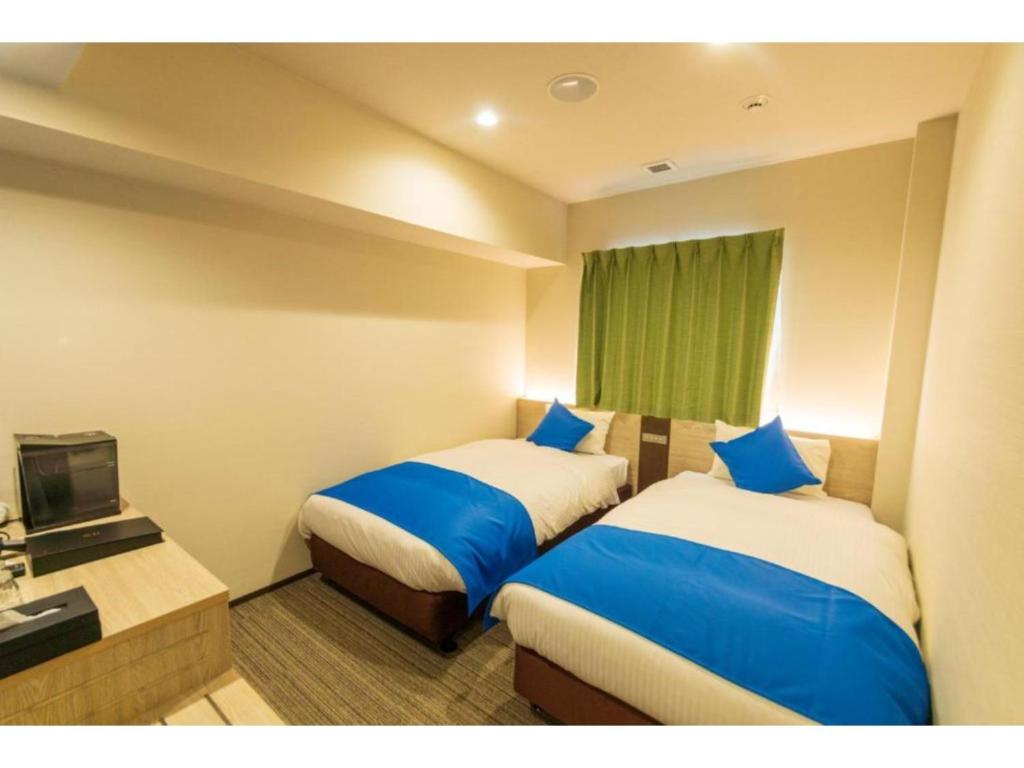 a hotel room with two beds and a television at HOTEL LANTANA Naha Kokusai Street - Vacation STAY 65442v in Naha