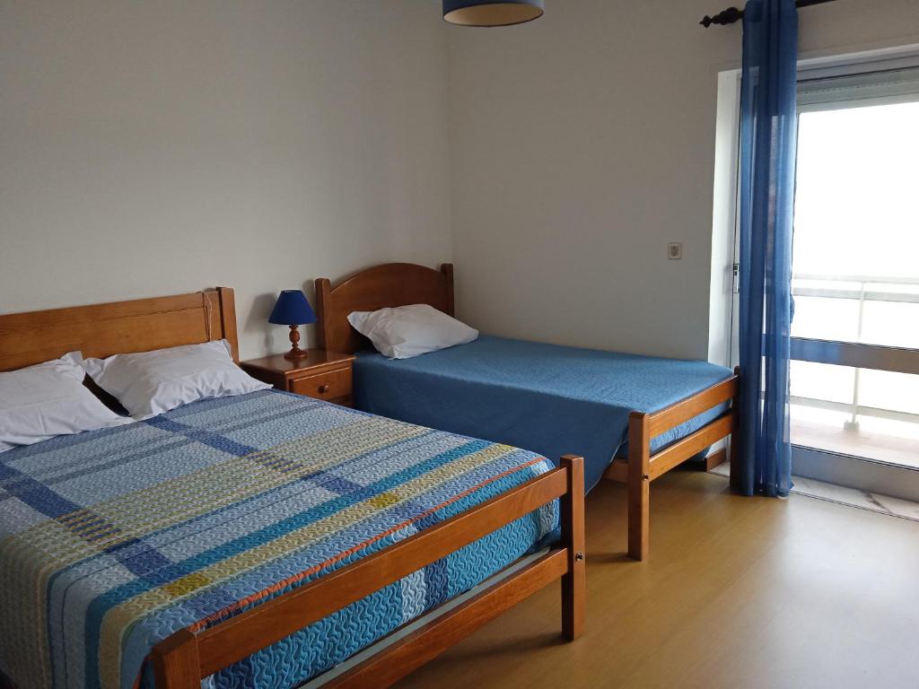 sypialnia z 2 łóżkami i oknem w obiekcie Canadian Star w mieście Praia de Mira