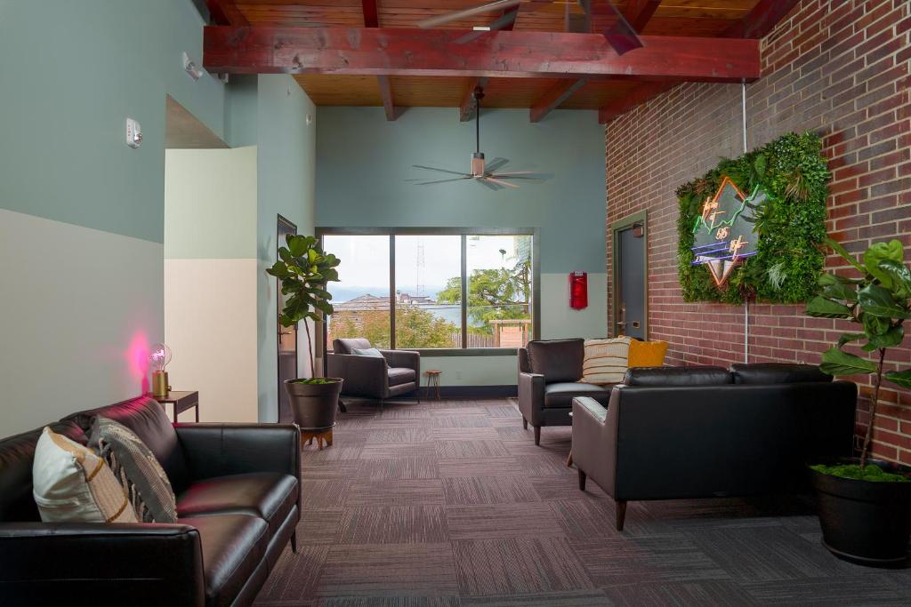 a living room with leather furniture and a brick wall at The Inn at 515 15th in Astoria, Oregon