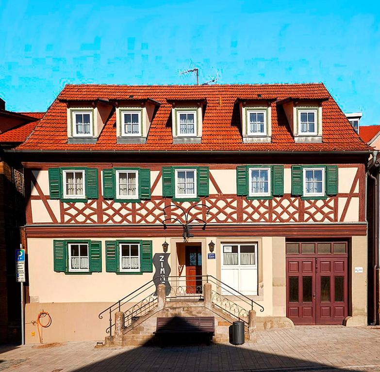 uma casa grande com uma estátua em frente em Unterkunft zu Krone em Hofheim in Unterfranken