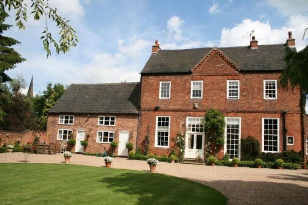 una gran casa de ladrillo rojo con patio en Self catering cottage in Market Bosworth, en Market Bosworth