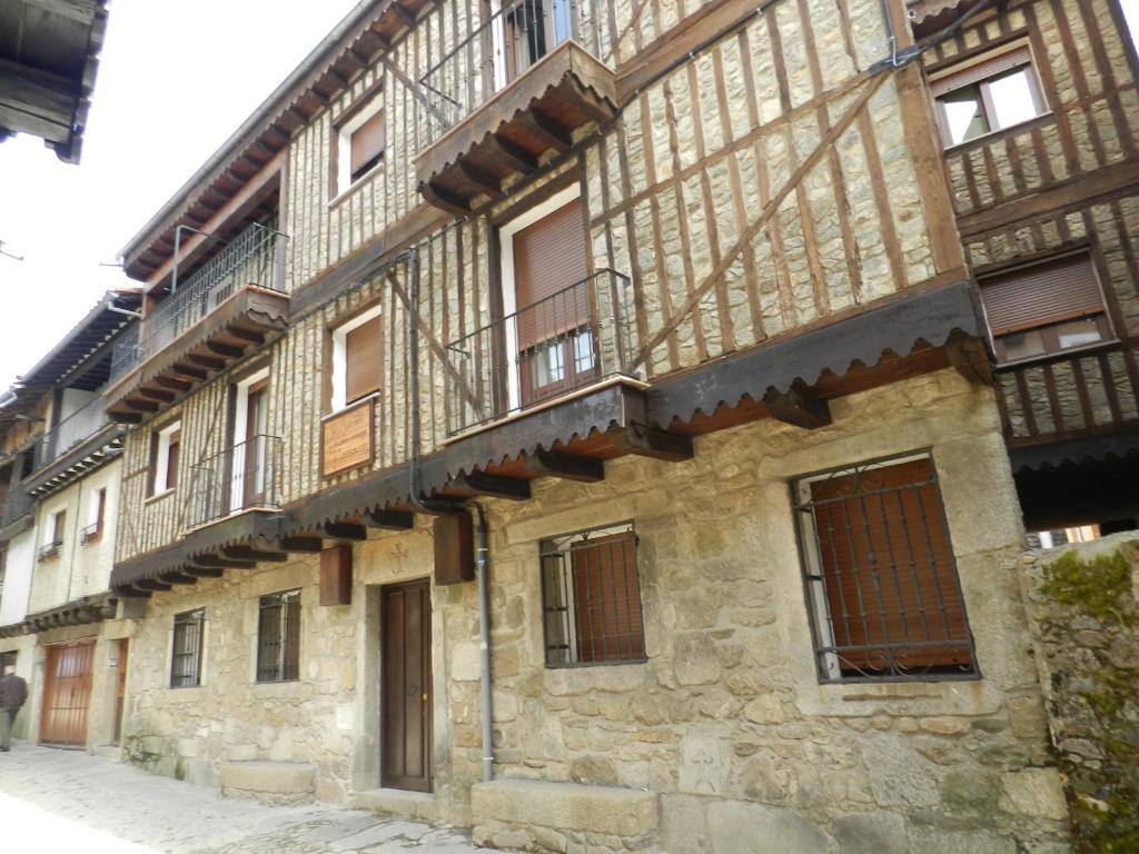 un antiguo edificio de piedra con balcones en una calle en VillaDolores, en La Alberca
