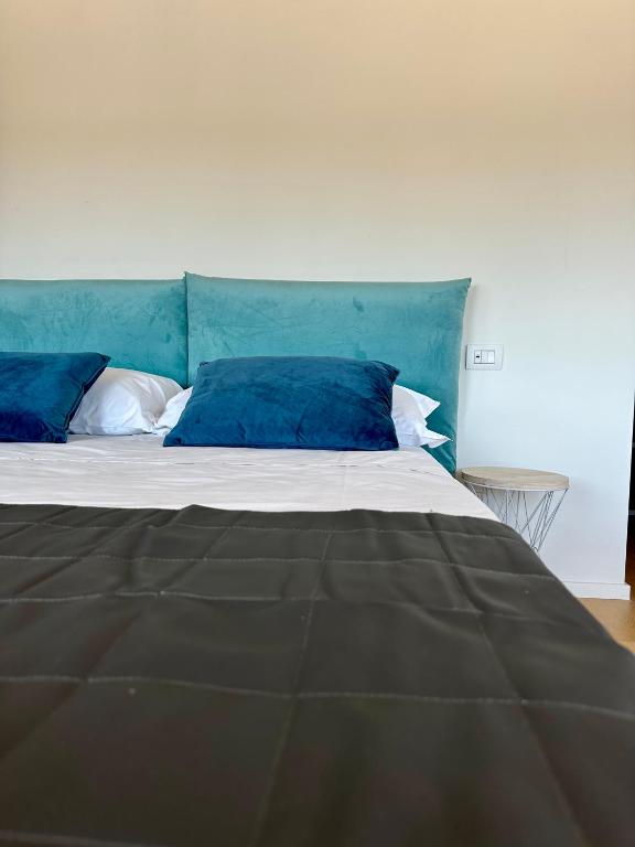 a bed with two blue pillows on top of it at C House Rooms Lake in Peschiera del Garda