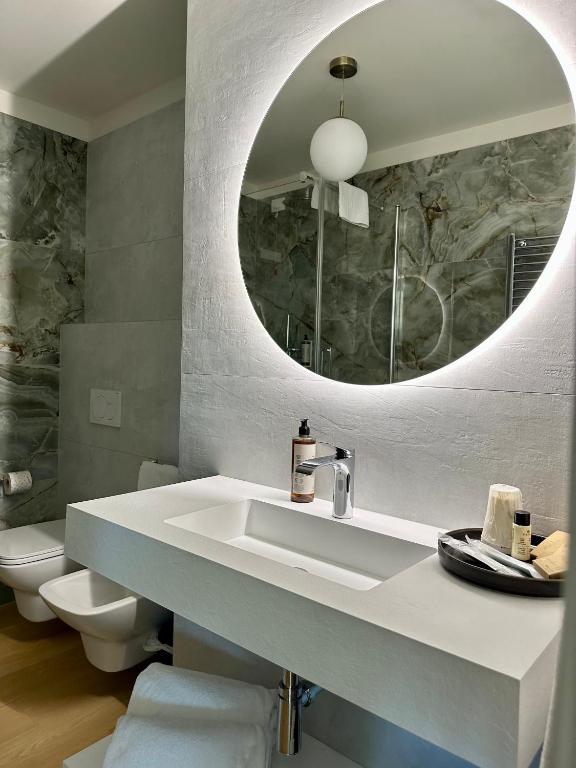 a bathroom with a sink and a mirror at C House Rooms Lake in Peschiera del Garda