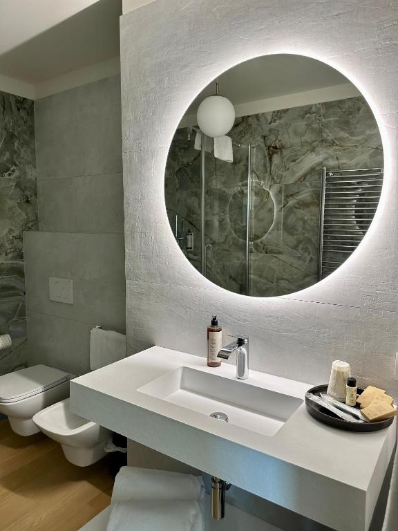 a bathroom with a white sink and a mirror at C House Rooms Lake in Peschiera del Garda