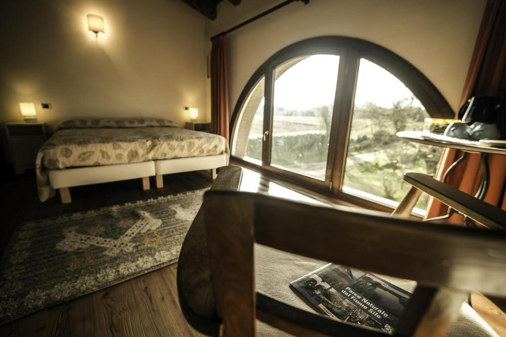 a bedroom with a bed and a large window at Bed and Breakfast Sile e Natura in Sant'Elena di Silea