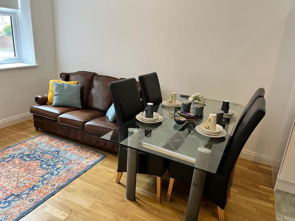 a dining room with a table and a couch at Quiet, Private and Serene in Southend-on-Sea