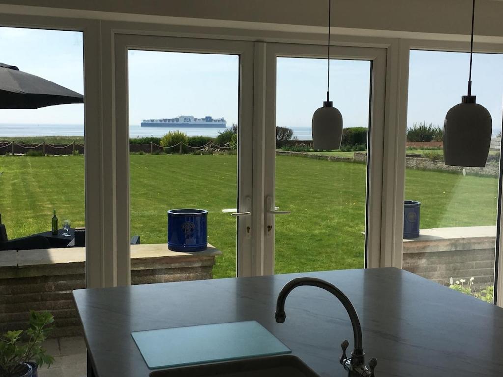 a kitchen with a table and a view of the ocean at Sea View Luxury Beach House in Crosby