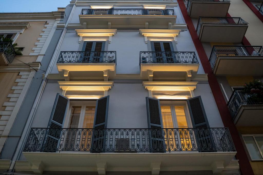 eine Fassade eines Gebäudes mit Balkonen und Lichtern in der Unterkunft CASA ALMIKA PRINCIPE AMEDEO in Bari