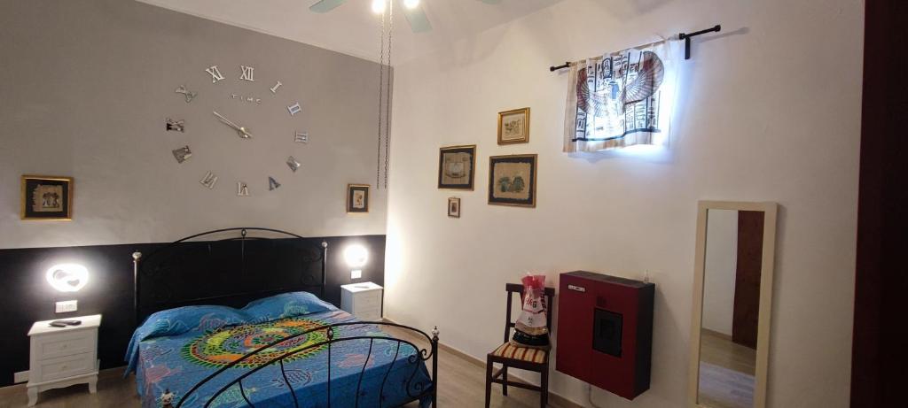 a bedroom with a bed and a clock on the wall at Appartamento Giada in Noto