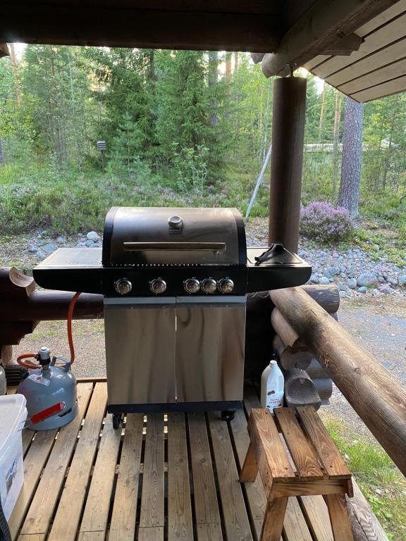 a grill sitting on top of a wooden deck at Mökki järven rannalla mäntymetsässä in Forssa