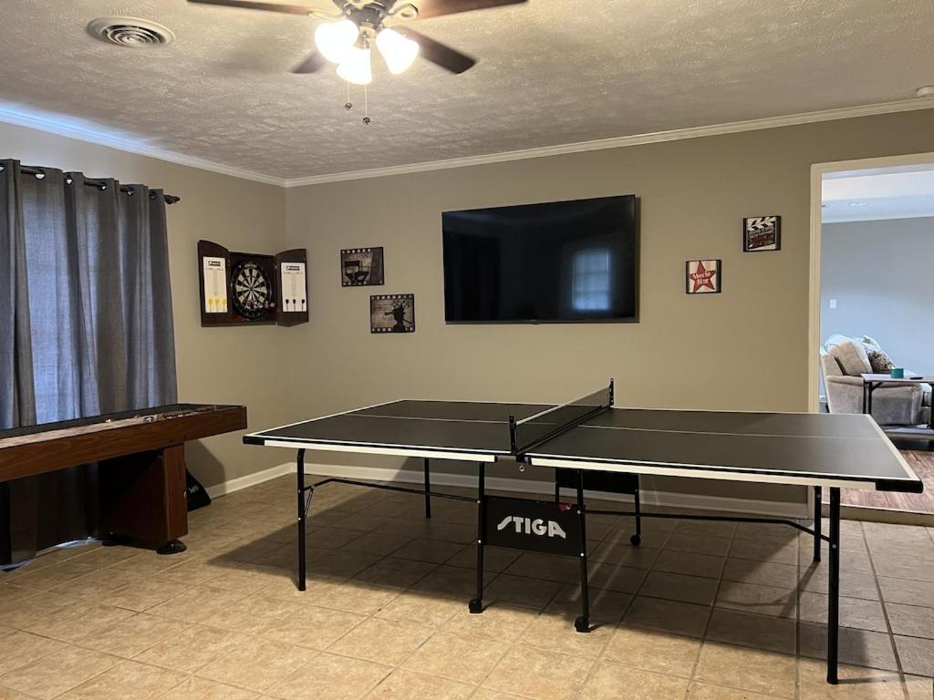 a ping pong table in a living room with a tv at Spacious 3 bedroom home near Amphitheater/Baseball/shopping and much more in Pearl