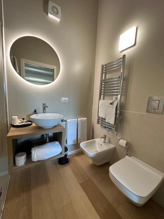 a bathroom with a sink and a toilet and a mirror at C House Rooms Lake in Peschiera del Garda