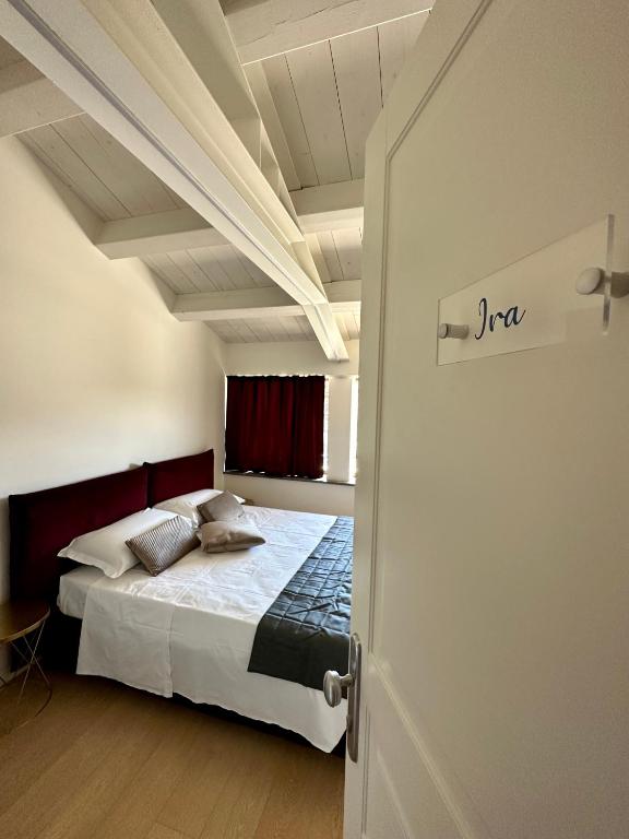 a bedroom with a bed in a room with a door at C House Rooms Lake in Peschiera del Garda
