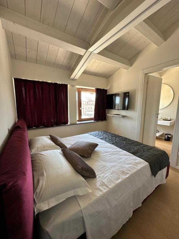 a bedroom with a large bed with two pillows on it at C House Rooms Lake in Peschiera del Garda