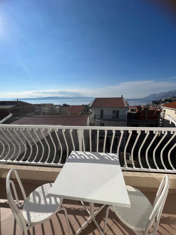 a white table and two chairs on a balcony at Apartments Jurisic in Baška Voda
