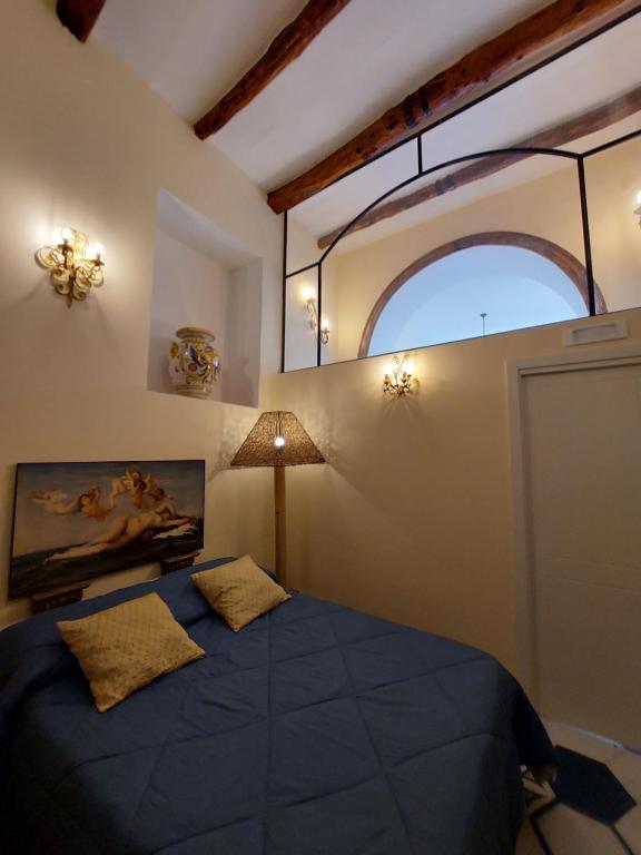 - une chambre avec un grand lit bleu et une fenêtre dans l'établissement Dimora storica "Le Stanze di Dioniso", à Naples