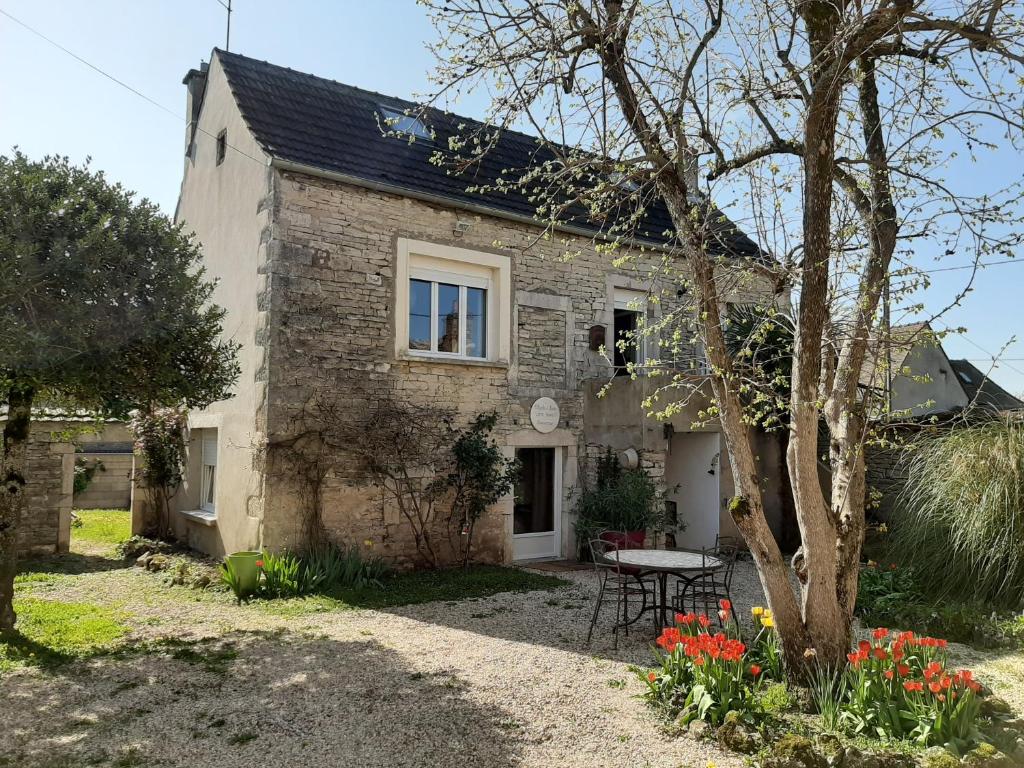 een stenen huis met een tafel ervoor bij Côte Dors in Corpeau