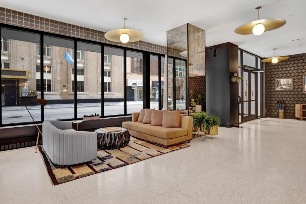 a lobby with a couch and chairs and windows at Hotel Indigo - Minneapolis Downtown, an IHG Hotel in Minneapolis