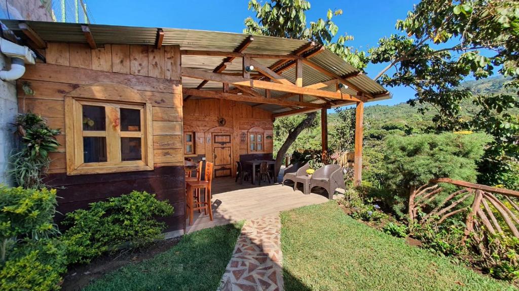 una pequeña casa de madera con terraza de madera en Casa Katok en Sonsonate