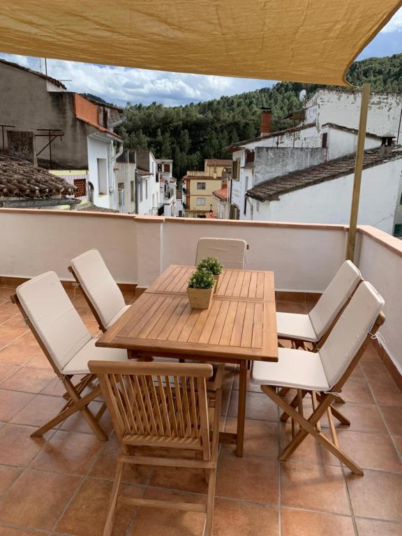 a wooden table and chairs on a balcony at Casa Rural El Rincón de Beatriz in Ayódar