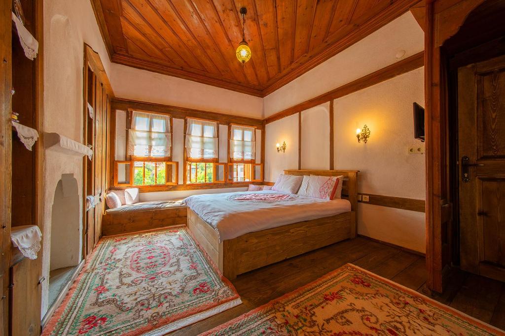 a bedroom with a bed and a wooden ceiling at Meymune Valide Konağı in Safranbolu