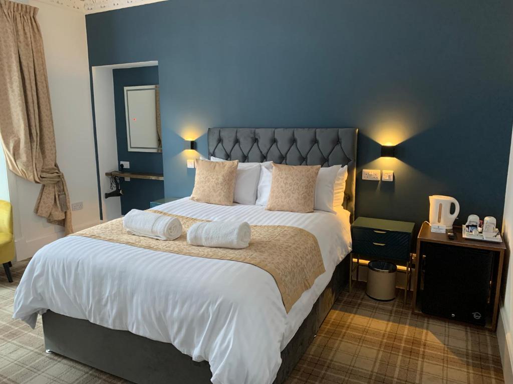 een slaapkamer met een groot bed met een blauwe muur bij Sandvilla Guesthouse in Oban