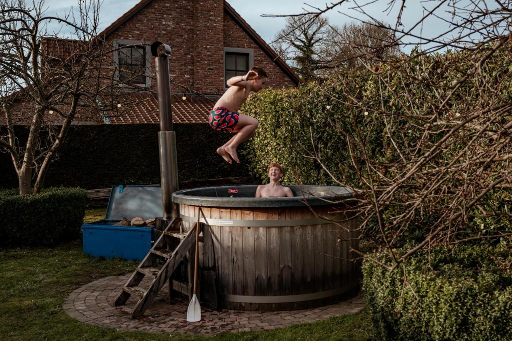 Un joven saltando a un jacuzzi en SintPieter17 Lo-Ghis vakantiewoning, en Voeren