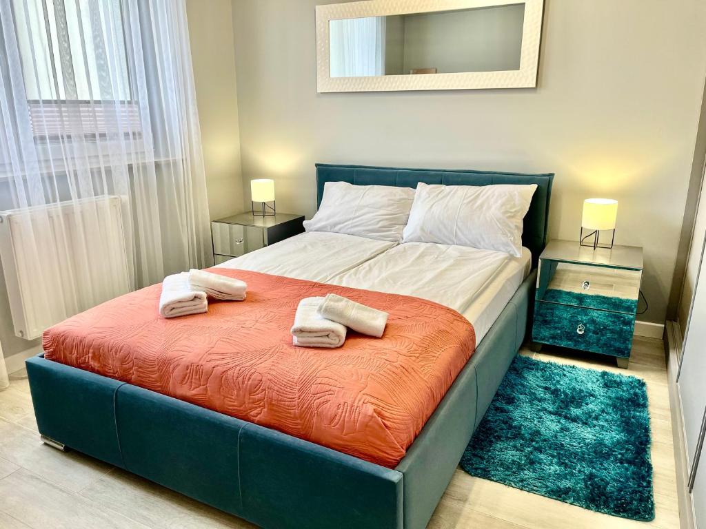 una camera da letto con un letto grande con asciugamani sopra di Apartamenty Planeta - Koszalin a Koszalin