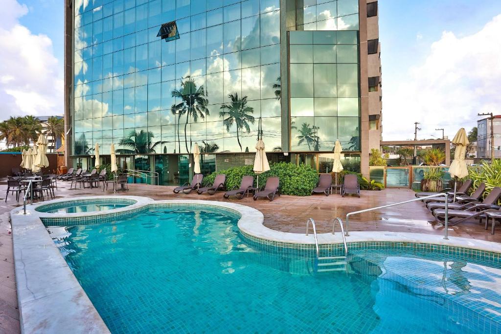 einem Pool vor einem Gebäude in der Unterkunft Ritz Suítes-Maceió, Flat a Beira mar de temporada in Maceió