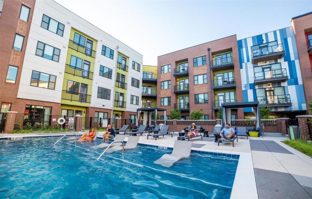 a group of people sitting around a swimming pool in a building at Free parking Gym & Pool Downtown at CityWay in Indianapolis