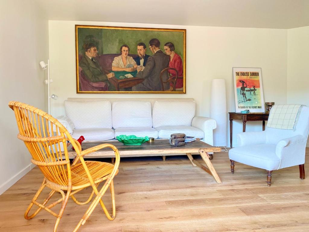 un soggiorno con divano e un dipinto di Guethary superbe appartement centre proche plage a Guéthary