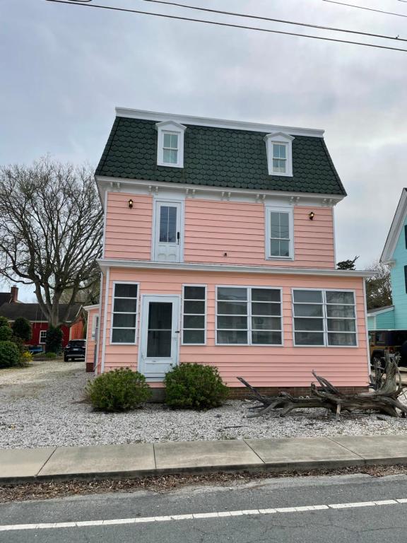 een roze huis met een zwart dak bij Seaside Retreat in Wachapreague