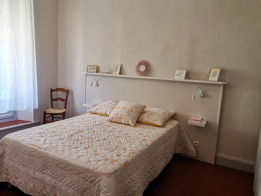 ein Schlafzimmer mit einem Bett mit zwei Kissen darauf in der Unterkunft Appartement cozy au cœur du village in Roquebrune-sur-Argens