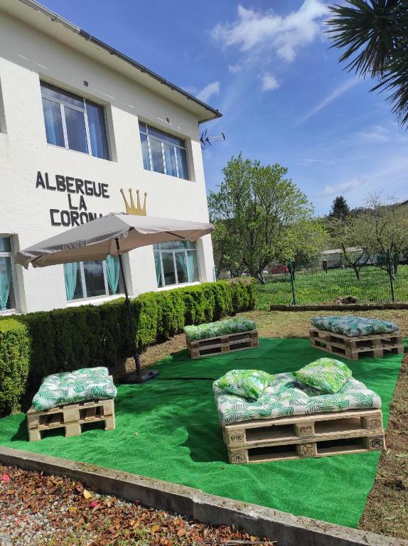 un hôtel avec 3 lits sur une pelouse verdoyante dans l'établissement Albergue La Corona1, à O Pino 
