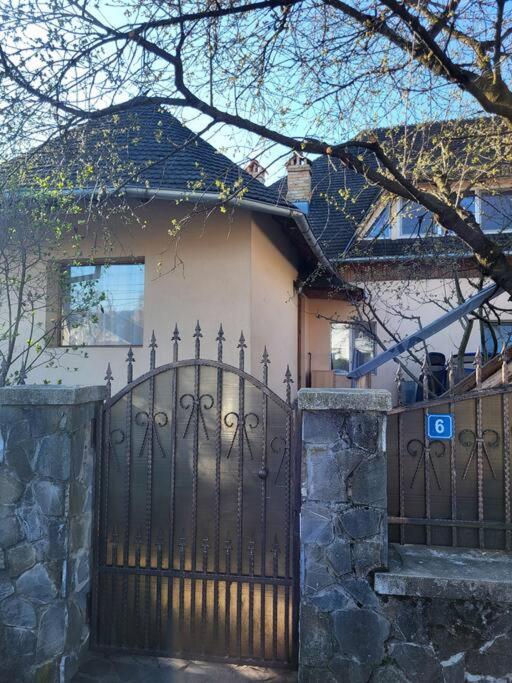 a house with a black iron gate and a house at Casa Roza in Breaza de Sus
