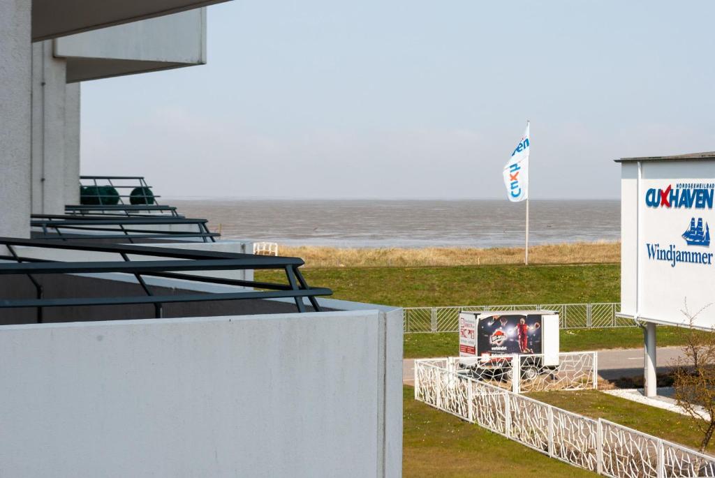 Una vista del océano desde la playa con un cartel. en Haus Hanseatic, Wohnung 211, en Duhnen