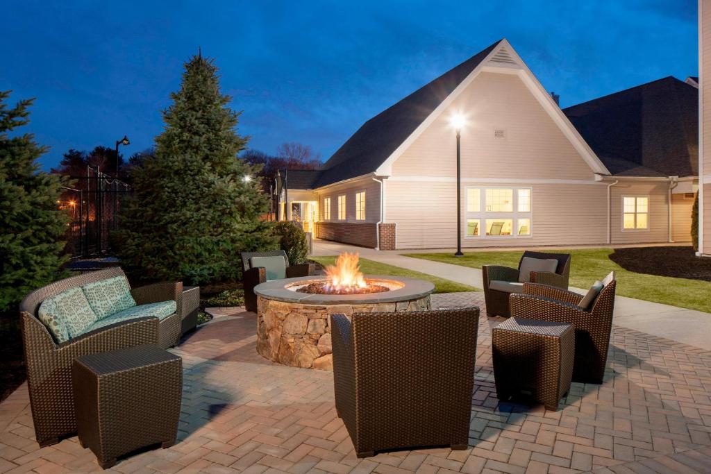 a patio with a fire pit and chairs and a house at Residence Inn Boston Norwood in Norwood