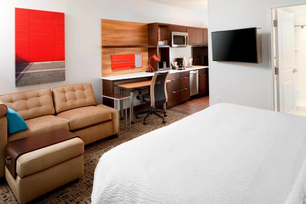 a hotel room with a bed and a desk and a couch at TownePlace Suites by Marriott Columbus Easton Area in Columbus