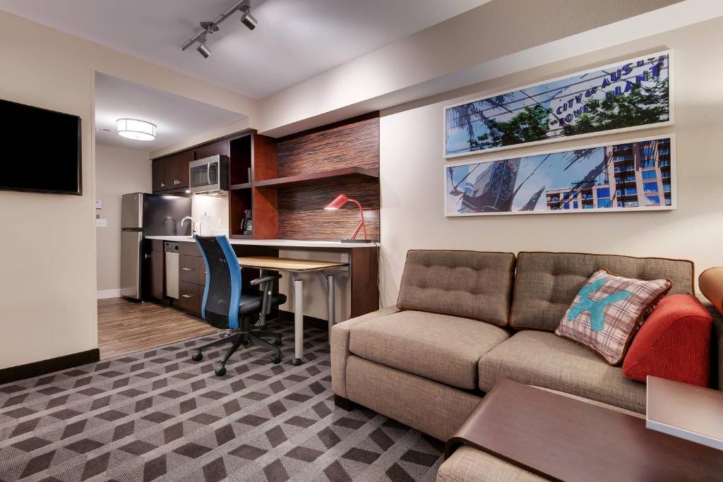 ein Wohnzimmer mit einem Sofa und einem Schreibtisch in der Unterkunft TownePlace Suites by Marriott Austin Parmer/Tech Ridge in Austin