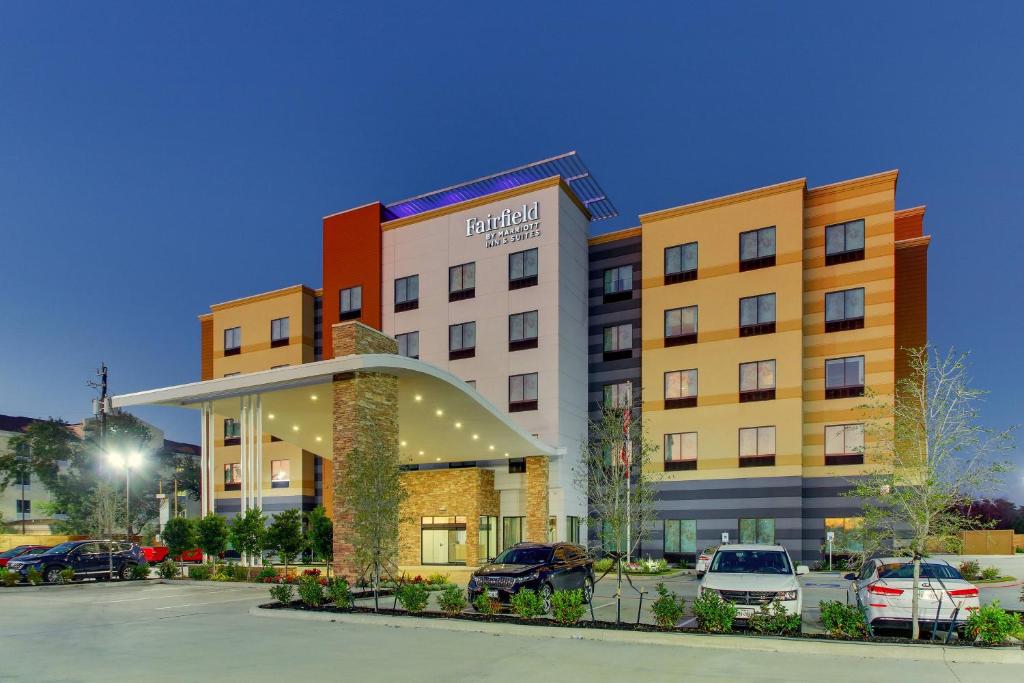 a hotel with cars parked in a parking lot at Fairfield Inn and Suites by Marriott Houston Brookhollow in Houston