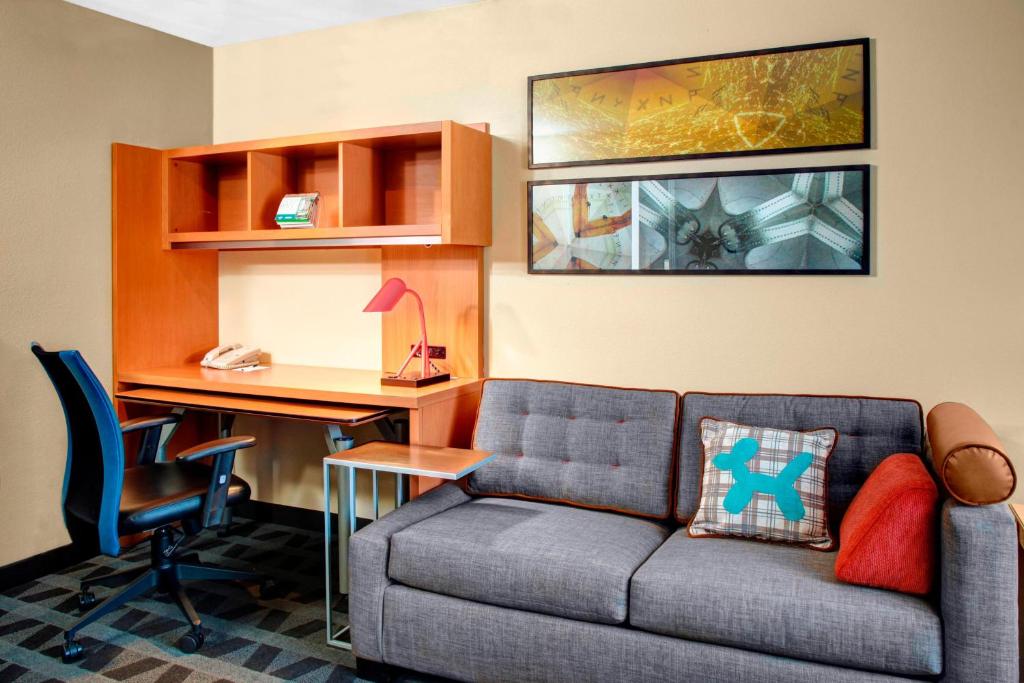 TownePlace Suites Fresno في فريسنو: غرفة معيشة مع أريكة ومكتب