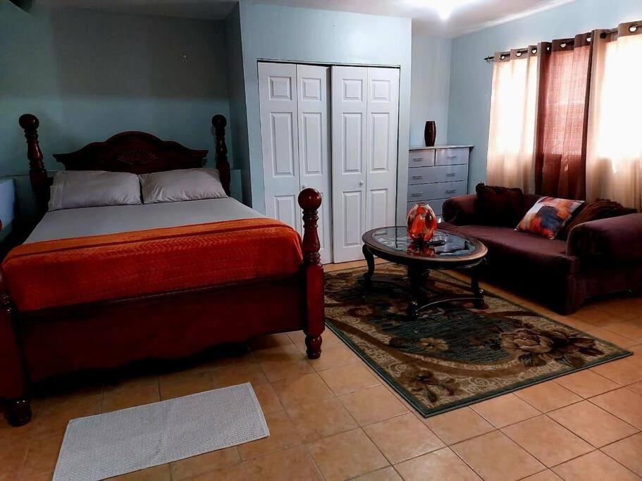 sypialnia z łóżkiem, stołem i kanapą w obiekcie Comfort Cottage at the Grove w mieście Mandeville