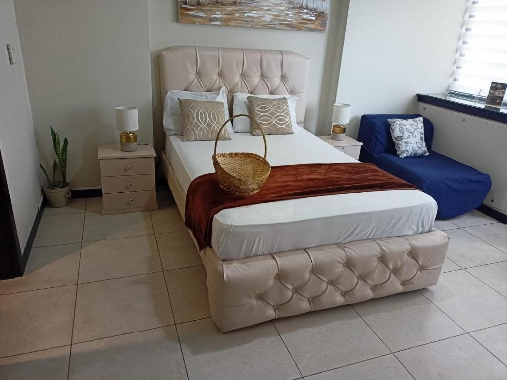 1 dormitorio con 1 cama grande y cabecero grande en Ecusuites Room 44 bellini Gye Santa Ana, en Guayaquil